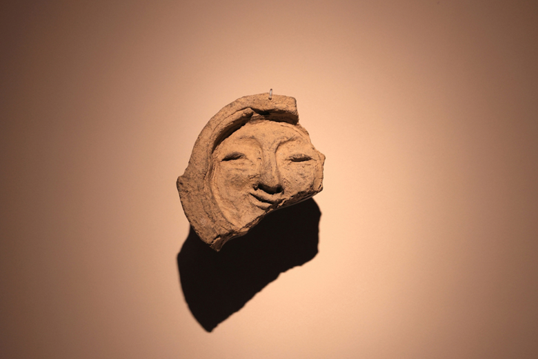 Front view of the “Smile of Silla,” a human-face tile from the Silla period at the National Gyeongju Museum. This timeless design inspired the APEC 2025 Korea emblem, alongside a butterfly symbol of connection and innovation.